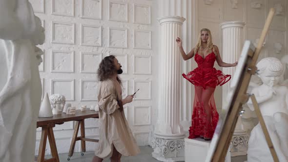 a Bearded Man with Long Hair and a Shirt on a Naked Body Looks at a Blonde in a Red Dress