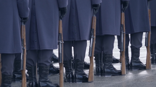 Soldiers in Blue Uniforms and Black Boots, Holding a Gun and Standing in a Line