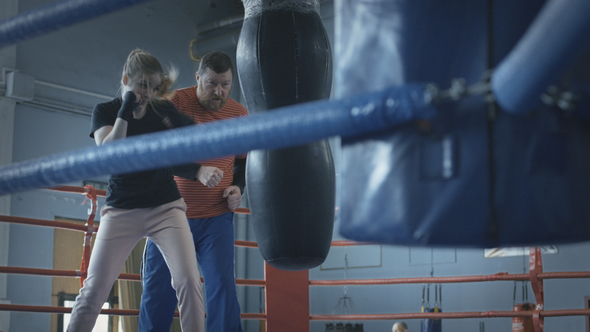 Woman Boxing with Trainer on Ring