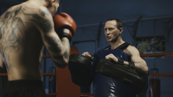 Serious Tattooed Boxer Training with Coach