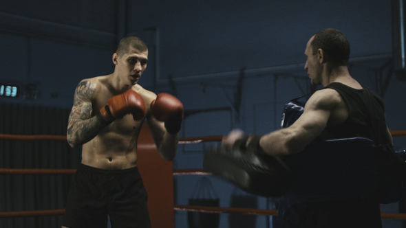 Serious Tattooed Boxer Training with Coach