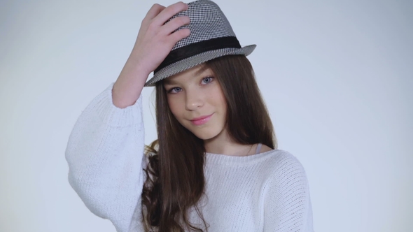 Pretty Young Girl Plays with Hat and Wears on Head with Cute Smile