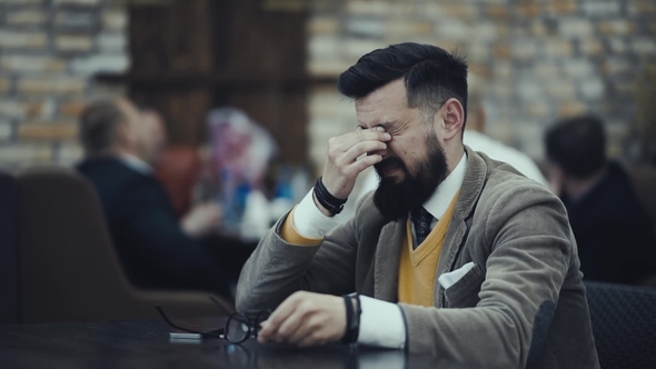 Bearded Businessman in Glasses Bears Losses From Fatigue Rubs His Eyes