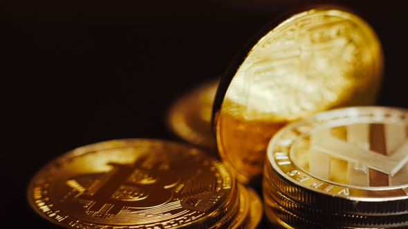 Shot of Bright Litecoin and Golden Bitcoins Rotating on Dark Background