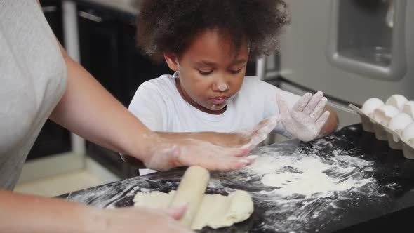 Family Baking Black Little Girl and Her Mother Making Cupcakes in the Kitchen the Girl Covered in