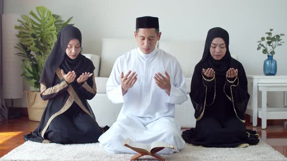 Young Islamic people praying with reading the Quran