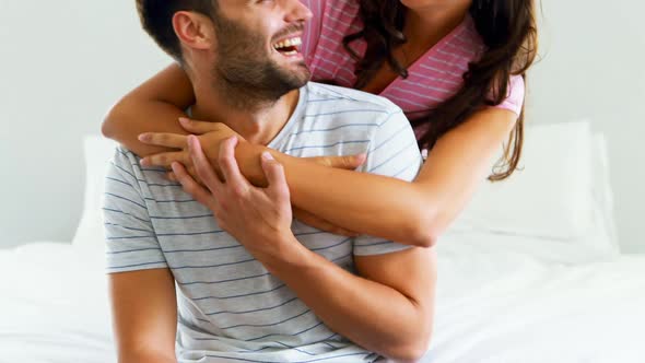 Portrait of couple embracing each other in bedroom