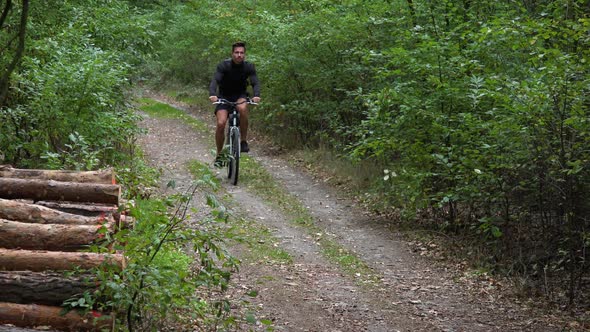 A Cyclist Rides Down a Path Through a Rural Area - Top Front View