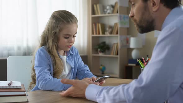 Disobedient Daughter Playing Game on Smartphone and Ignoring Displeased Dad