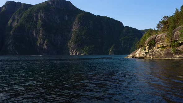 Norwegian fjord recorded at morning with motorboat in the background.