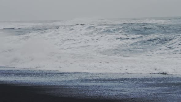 Misty Sea Stacks And Crashing Sea On Black Sand Beach