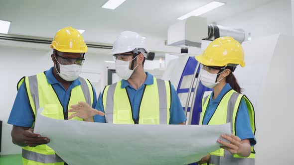 Group of diversity worker people wearing protective face mask in production factory due to covid 19.