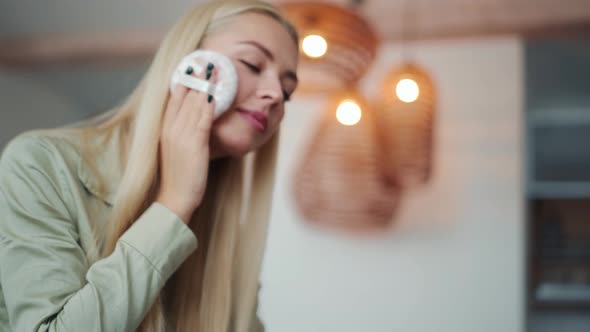 Happy blond woman powder the face with a sponge