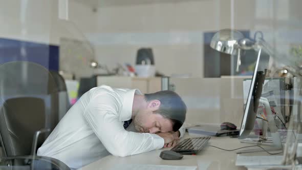 Sleepy Middle Aged Businessman Having Nap While Working in His Office