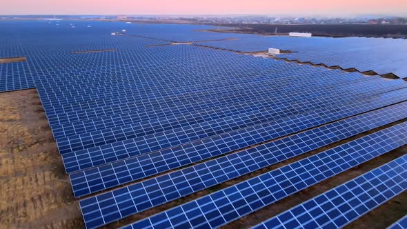 Aerial Drone View of Large Solar Panels at a Solar Farm at Bright Sunset in Early Winter