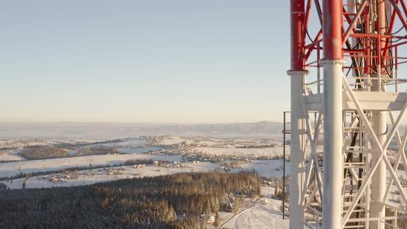 Aerial rising beside tall communication tower, telephone connection pole