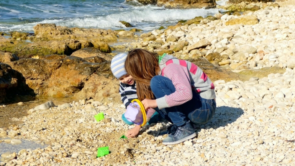 A Girl Is Playing on the Beach with a Little Boy