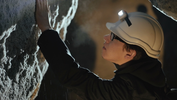 Two Speleologists Exploring the Cave's Calcareous Wall