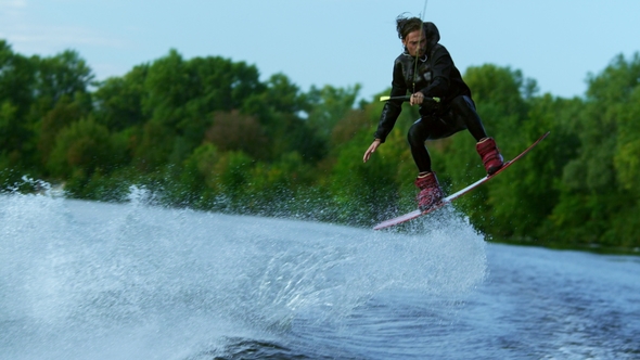 Man Riding Board on Waves of River Training Process of Waterskiing