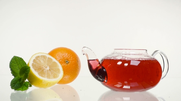 Red Rose Tea in a Glass Teapot and a Cup on a White Background