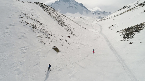 Skier and Snowboarder in Peak Mountains