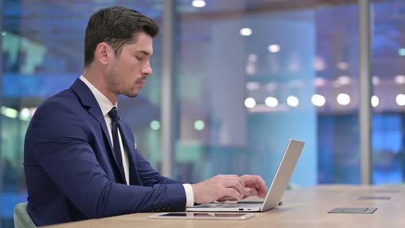 Businessman Working on Laptop in Office