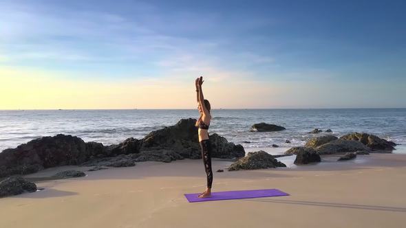 Girl with Ponytail Bends Body on Beach under Blue Sky