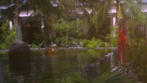 Girl with Phone Walks by Fountain Pond in Tropical Park