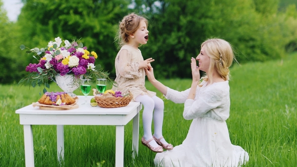 A Young Family Is Having Fun in Nature, Eating Sweets and Having Fun. St. Patrick's Day Picnic