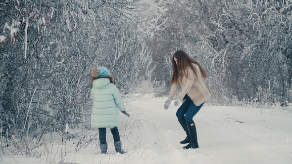 Mom and Daughter Throw Snowballs