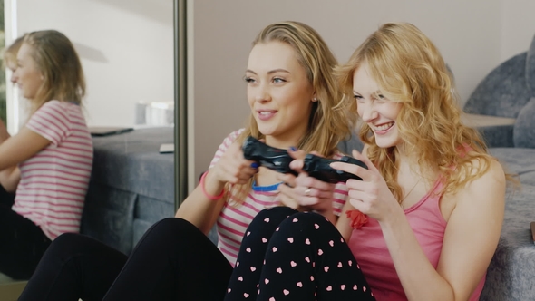 Two Teen Girls Playing on the Console. Have Fun Together