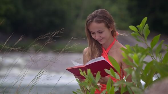 Girl Reads Book at River and Branches on Foreground