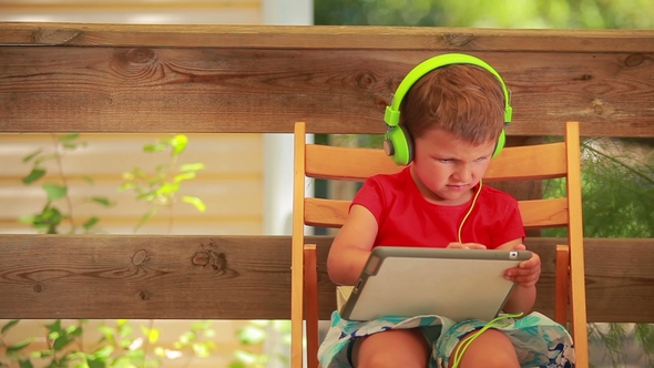 Boy Listening To Music on Green Headphones