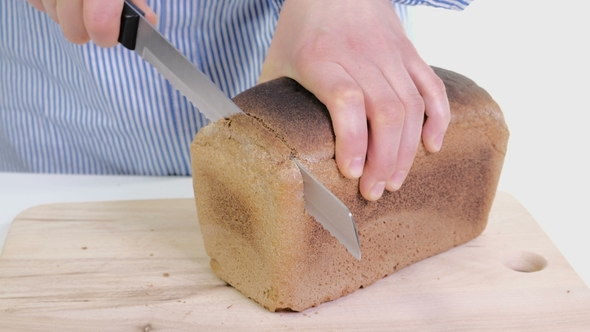 Female Hands Cutting Freshly Bread