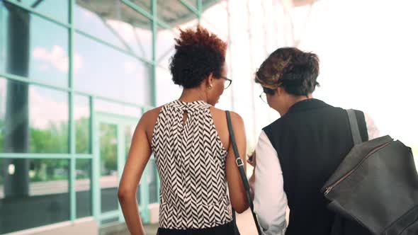 Colleagues Walking Down Street Looking at Phone Speaking Business Centre Background