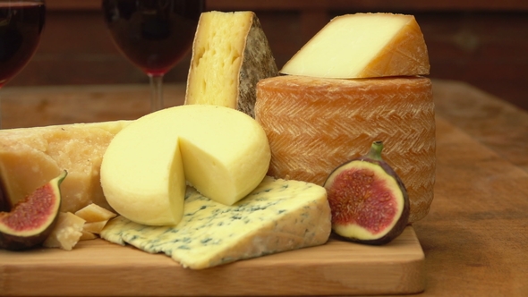 Pieces of Cheese, Wine and Figs on a Wooden Table