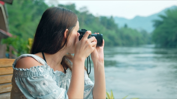 Young Woman Tourist Looking at Camera and Taking Pictures of Beautiful Landscape