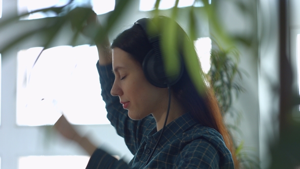 Joyful Woman Enjoying Music in Headphones at Home