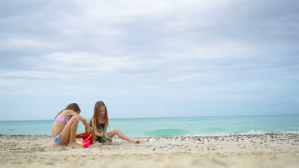 Adorable Little Girls Playing with Beach Toys During Summer Vacation on the Beach