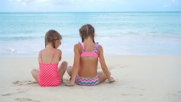 Adorable Little Girls Playing with Sand on the Beach