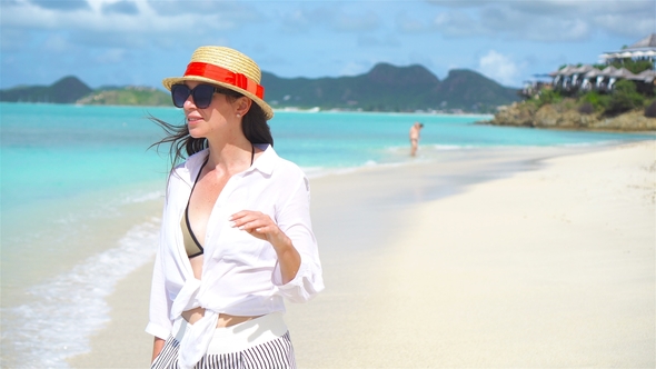 Young Fashion Woman in Hat on the Beach