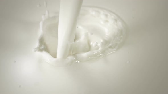 Close-up pouring milk in Slow Motion with crown splash