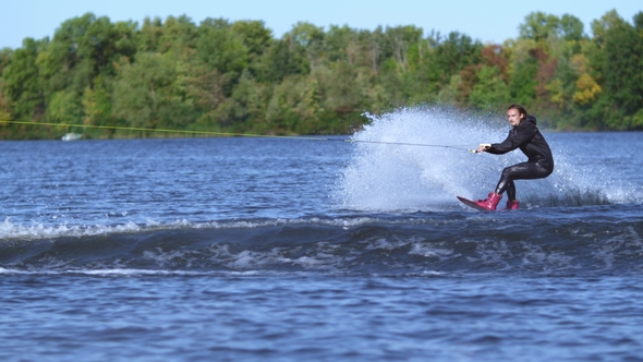 Wakeboarder Jumping High Above Water. Rider Wakeboarding