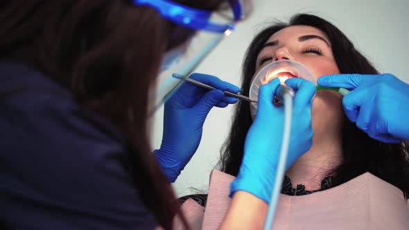 Professional Woman Dentist in Medical Gloves Examines Patient in Dental Clinic