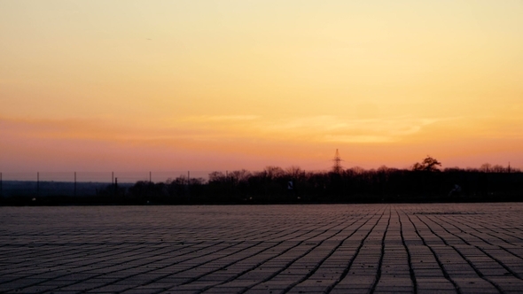 Silhouette of a Young Woman Who Rides on an ATV Over a Large Square in the Background of a Beautiful