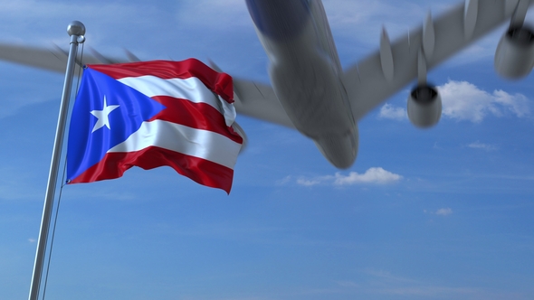 Commercial Airplane Flying Above Waving Flag of Puerto Rico