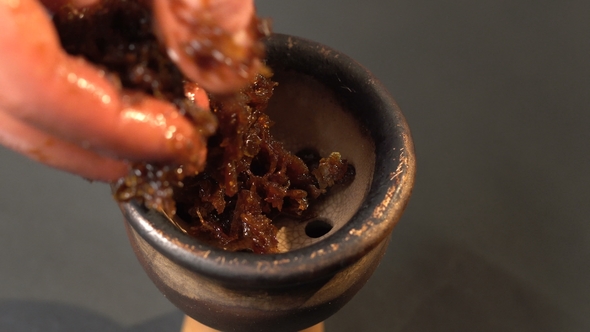 Hand Lays the Fragrant Juicy Red Tobacco in the Hookah Bowl