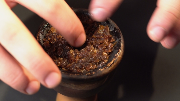 Leveling of Tobacco with Fingers in a Bowl for a Hookah