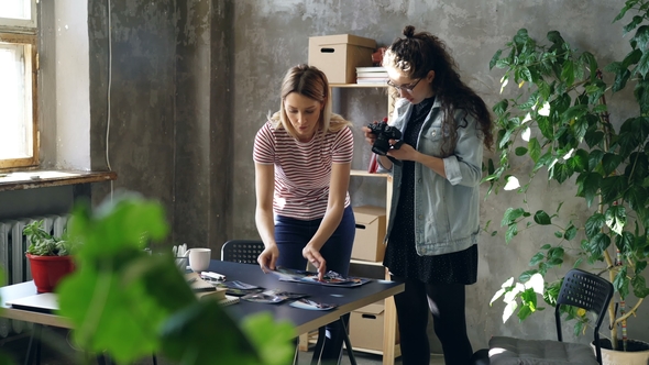 Young Female Enterpreneurs Are Placing Photos on Table To Make Flat Lay and Shooting with Camera