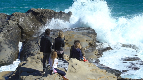 People Enjoy the Sun and Waves on the Coastal Cliffs